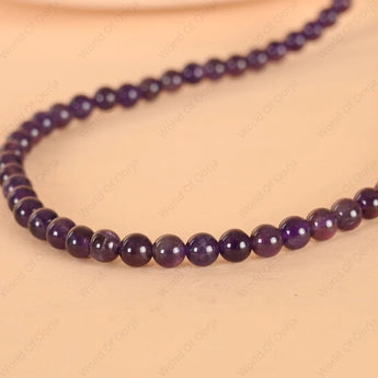 Purple beaded necklace on a beige background
