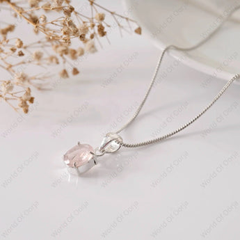 Silver necklace with a pink gemstone pendant on a light background