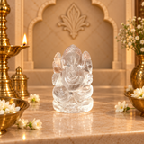 Clear Quartz Sphatik Ganesh Ji murti on a marble altar with brass diya