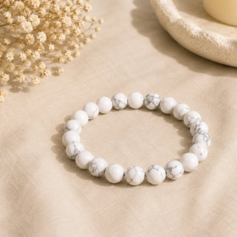 Howlite bracelet with opaque white beads and fine grey veining on cream linen with dried white flowers – World of Oorja