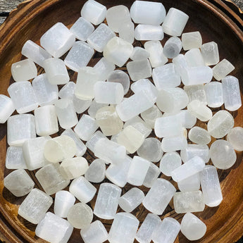 Natural Selenite Tumble Stone – Energy Cleansing & Healing Crystal pieces on a wooden tray