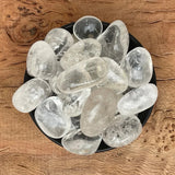 Natural Clear Quartz Crystal – Healing & Energy Amplifying Stone in a black bowl on a wooden surface