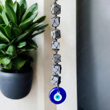 Black Tourmaline cubes with blue Evil Eye charm for protection and energy cleansing