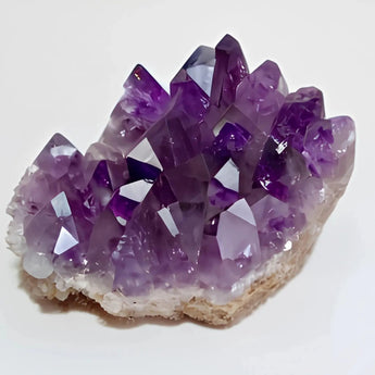 Amethyst crystal cluster on a white background
