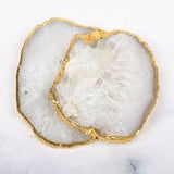 Close-up of a piece of white Agate coasters with gold inlay on a marble surface