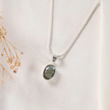 Natural labradorite pendant in silver prong setting on chain — front view showing blue flash