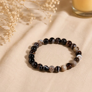 Sulemani Hakik bracelet with black, brown and cream banded agate beads on cream linen with dried baby breath – World of Oorja
