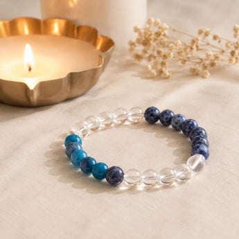 Weight Loss bracelet with clear quartz, teal blue apatite and navy sodalite beads on cream linen with a lit brass diya – World of Oorja